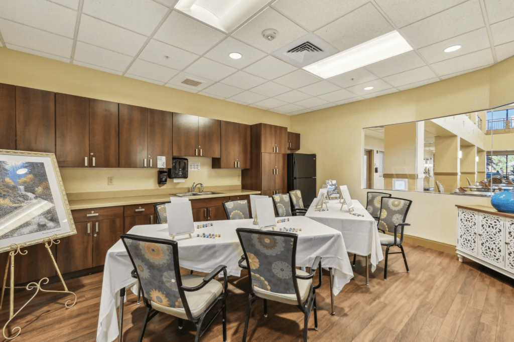 - The Preserve Community activity room with tables set for arts and crafts, featuring chairs, cabinets, and a kitchenette.